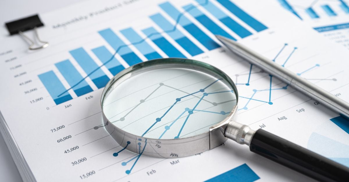 magnifying glass and stock market papers